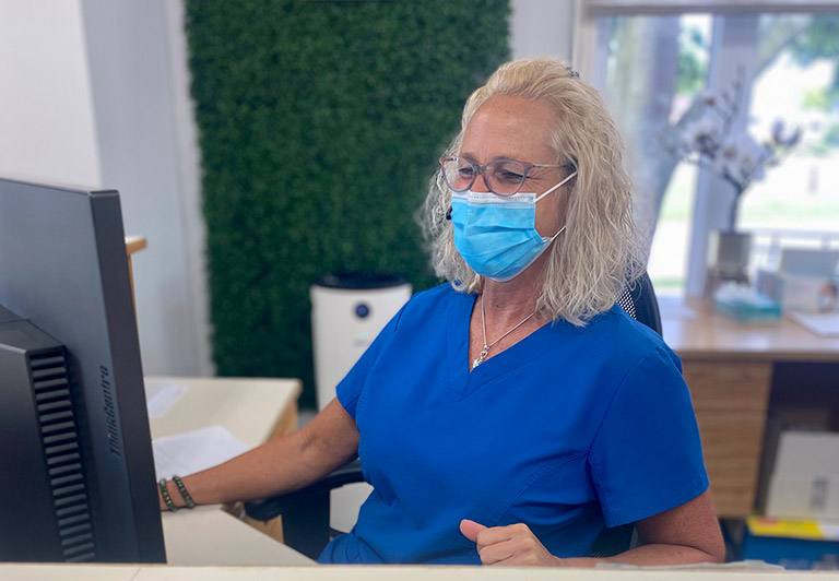 woman at front desk wearing mask